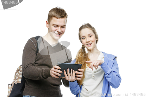 Image of Teen boy and girl standing with mobile phones