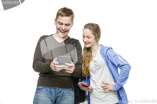 Image of Teen boy and girl standing with mobile phones