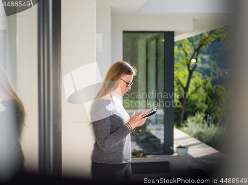 Image of women using tablet computer in front of luxury home villa