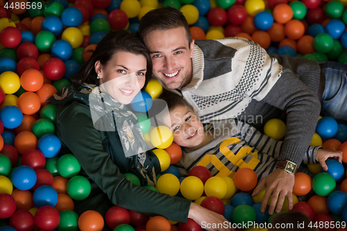 Image of young parents with kids in a children\'s playroom