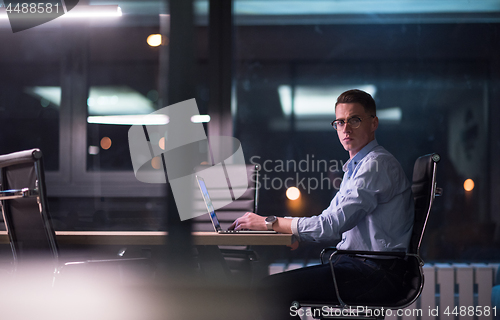 Image of man working on laptop in dark office