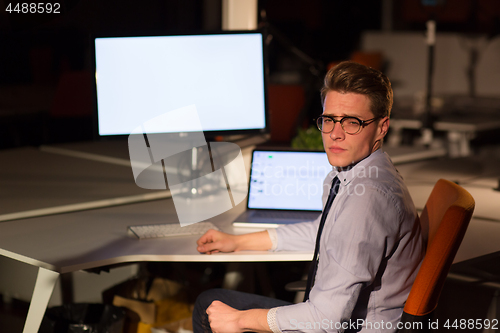 Image of man working on computer in dark office