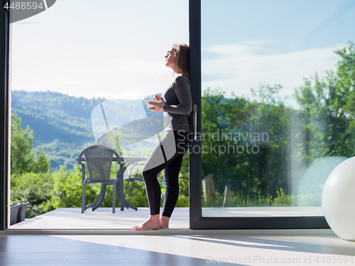 Image of woman eating breakfast in front of her luxury home villa