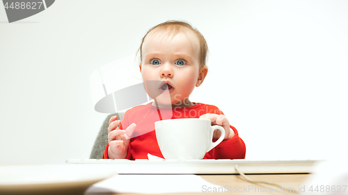 Image of Happy child baby girl toddler sitting with keyboard of computer isolated on a white background