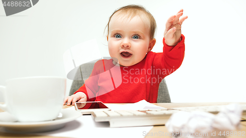 Image of Happy child baby girl toddler sitting with keyboard of computer isolated on a white background