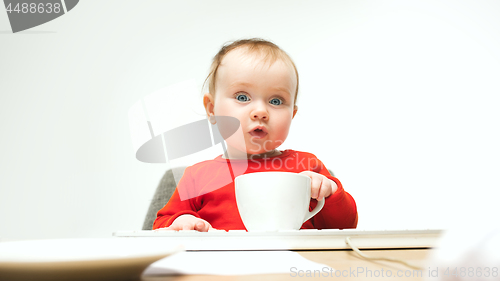 Image of Happy child baby girl toddler sitting with keyboard of computer isolated on a white background