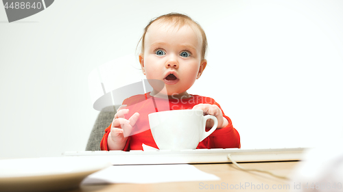 Image of Happy child baby girl toddler sitting with keyboard of computer isolated on a white background