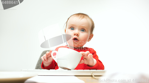 Image of Happy child baby girl toddler sitting with keyboard of computer isolated on a white background