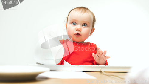 Image of Happy child baby girl toddler sitting with keyboard of computer isolated on a white background