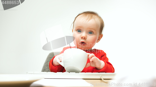 Image of Happy child baby girl toddler sitting with keyboard of computer isolated on a white background