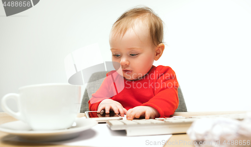 Image of Happy child baby girl toddler sitting with keyboard of computer isolated on a white background