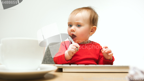 Image of Happy child baby girl toddler sitting with keyboard of computer isolated on a white background