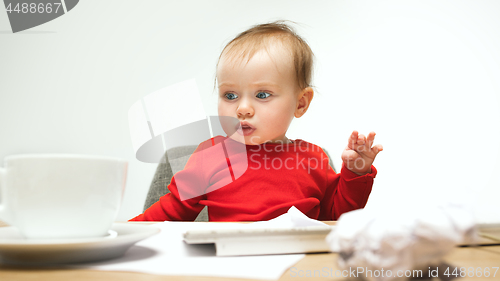 Image of Happy child baby girl toddler sitting with keyboard of computer isolated on a white background