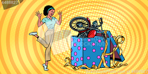 Image of motorcycle holiday gift box. African woman funny reaction joy
