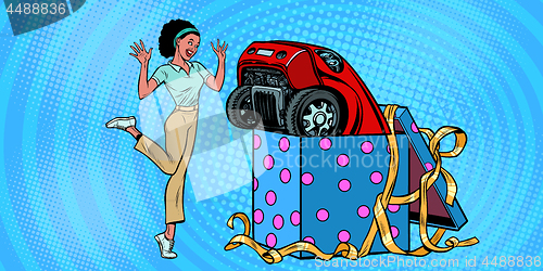 Image of car holiday gift box. African woman funny reaction joy