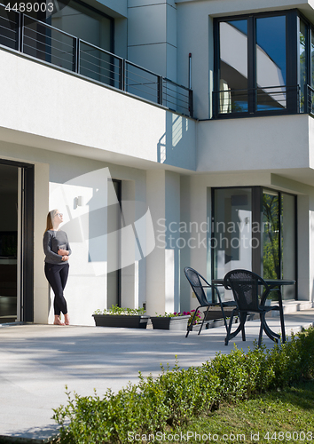 Image of women using tablet computer in front of luxury home villa