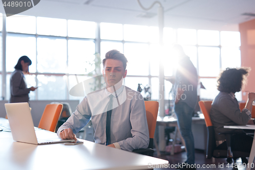 Image of businessman working using a laptop in startup office