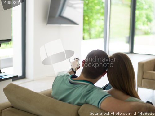 Image of Young couple on the sofa watching television