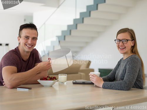 Image of couple enjoying morning coffee and strawberries