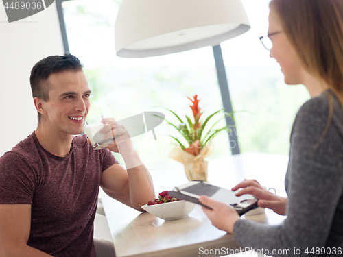 Image of couple enjoying morning coffee and strawberries