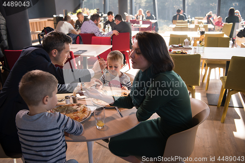 Image of Young parents enjoying lunch time with their children