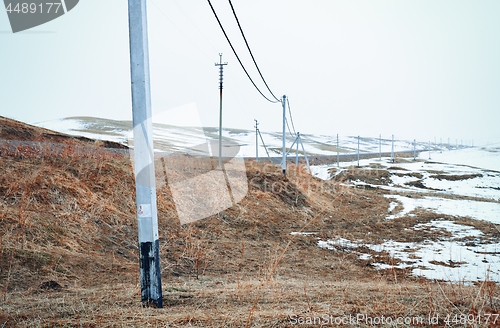 Image of Winter field with power line columns