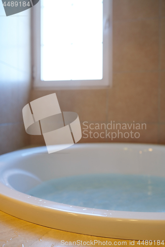 Image of Modern bathroom with bathtube full of water