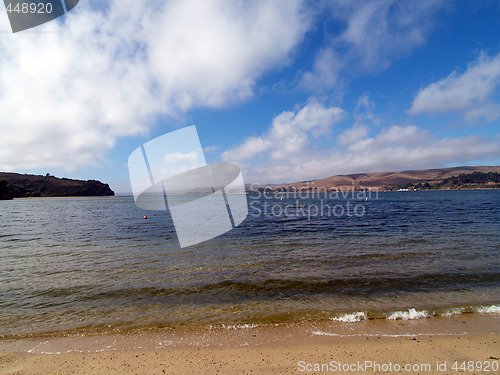 Image of wide angle view of small cove with water and clouds