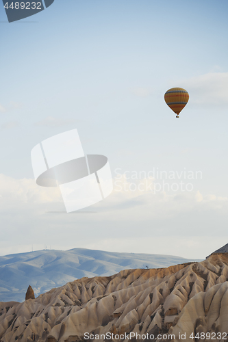 Image of Hot air balloon flying over the rocky land