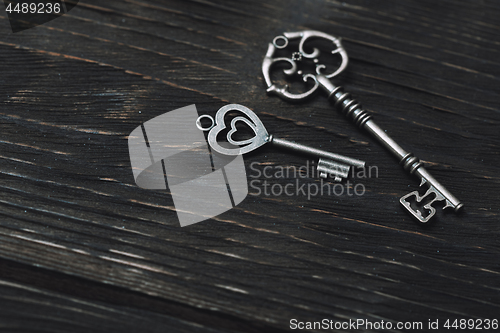 Image of Two vintage bronze keys on a wooden table