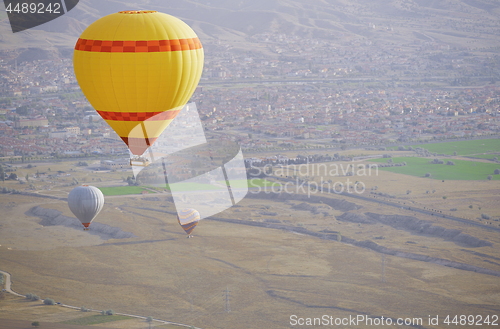 Image of Three air balloons flying over the land