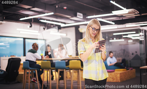 Image of blonde businesswoman working online using digital tablet