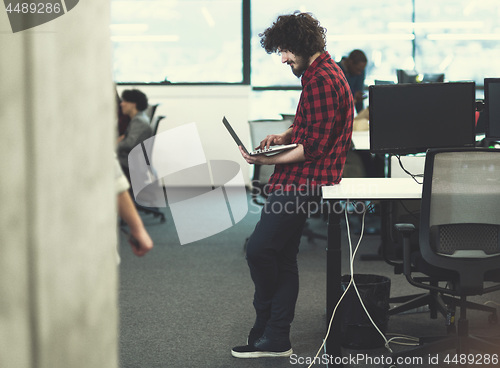 Image of smiling male software developer using laptop