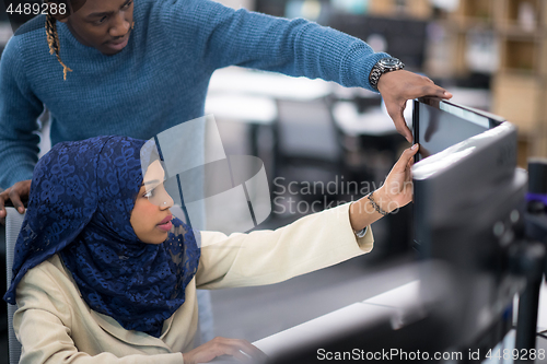 Image of young black muslim female software developer at work