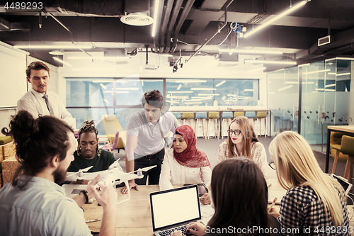 Image of multiethnic business team learning about drone technology