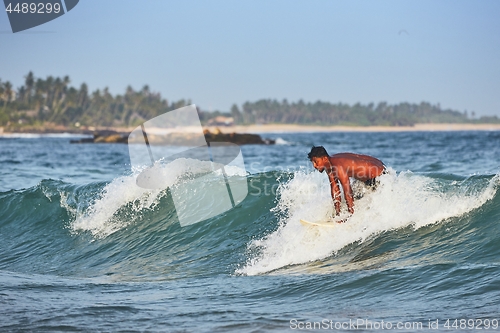 Image of Young man surfing in sea