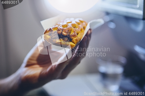 Image of Passenger enjoying snack in airplane