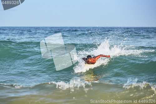 Image of Young man surfing in sea