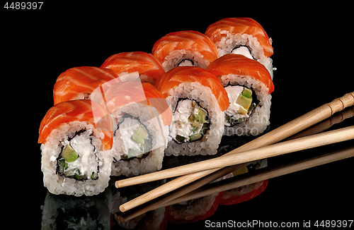 Image of Sushi rolls Philadelphia with chopsticks