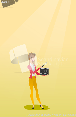 Image of Smiling woman holding an open clapperboard.