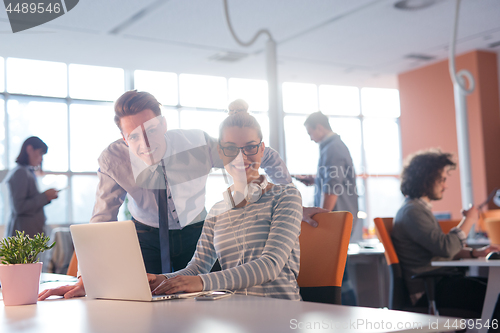 Image of Two Business People Working With laptop in office