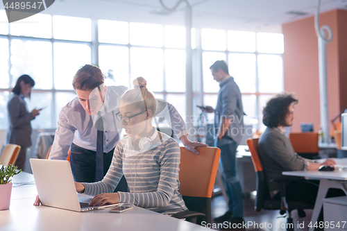 Image of Two Business People Working With laptop in office