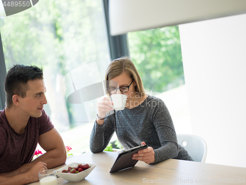 Image of couple enjoying morning coffee and strawberries