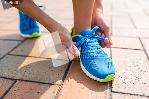 Image of Woman fixing the shoelace