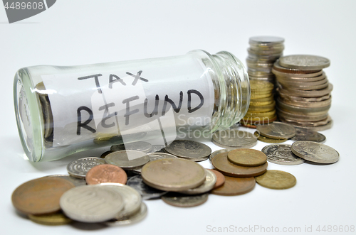 Image of Tax refund lable in a glass jar with coins spilling out 