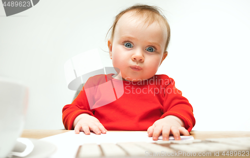 Image of Happy child baby girl toddler sitting with keyboard of computer isolated on a white background