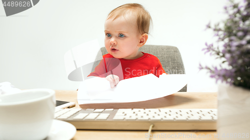 Image of Happy child baby girl toddler sitting with keyboard of computer isolated on a white background