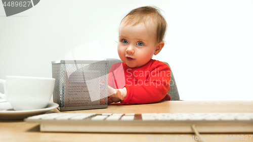 Image of Happy child baby girl toddler sitting with keyboard of computer isolated on a white background