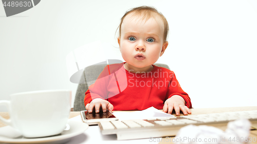 Image of Happy child baby girl toddler sitting with keyboard of computer isolated on a white background