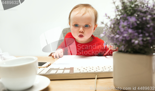 Image of Happy child baby girl toddler sitting with keyboard of computer isolated on a white background